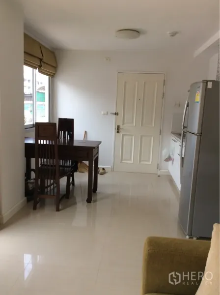 公寓 出售在Pathum Wan, Bangkok - 入户旁用餐区与紧凑厨房及冰箱，一居公寓靠近国家体育场BTS。