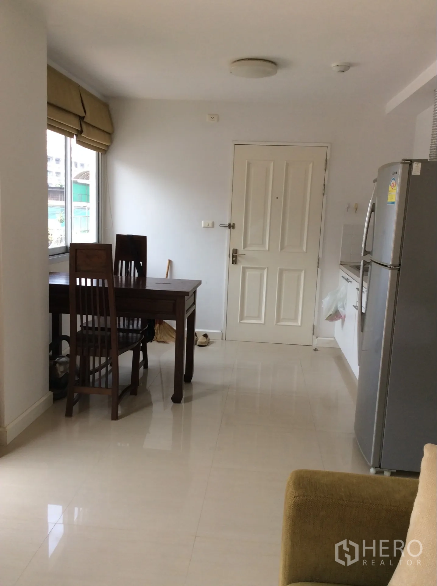 公寓 出售在Pathum Wan, Bangkok - 入户旁用餐区与紧凑厨房及冰箱，一居公寓靠近国家体育场BTS。