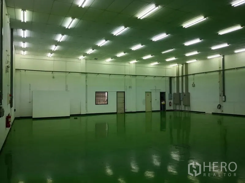 Warehouse for rent in Bang Phli, Samut Prakan - Open 600 sqm storage or production hall with smooth epoxy flooring, white walls and multiple access doors.