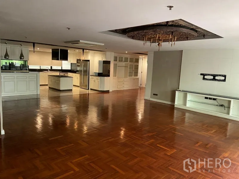 公寓 出售在Khlong San, Bangkok - 开阔的客餐一体空间，亮泽人字拼木地板，后方为大型白色厨房。