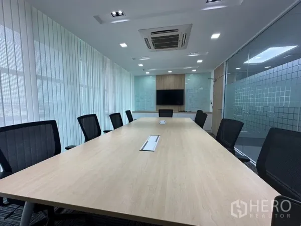 สำนักงาน ให้เช่า - ห้องประชุมสว่าง โต๊ะยาว เก้าอี้เมช ผนังกระจก และทีวีติดผนัง