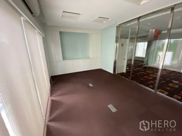 带办公室的家 出租在Wang Thonglang, Bangkok - 铺地毯的办公室，玻璃推拉隔断与白色柜体和百叶帘。