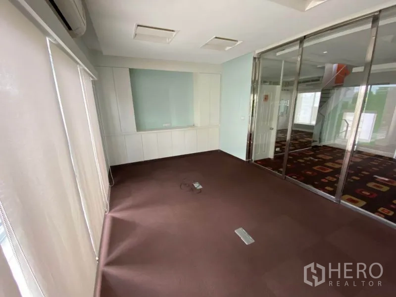 带办公室的家 出租在Wang Thonglang, Bangkok - 铺地毯的办公室，玻璃推拉隔断与白色柜体和百叶帘。