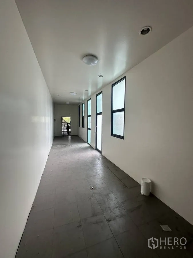 Home Office for rent in Taling Chan, Bangkok - Long internal corridor with side windows and door leading to an external landing.