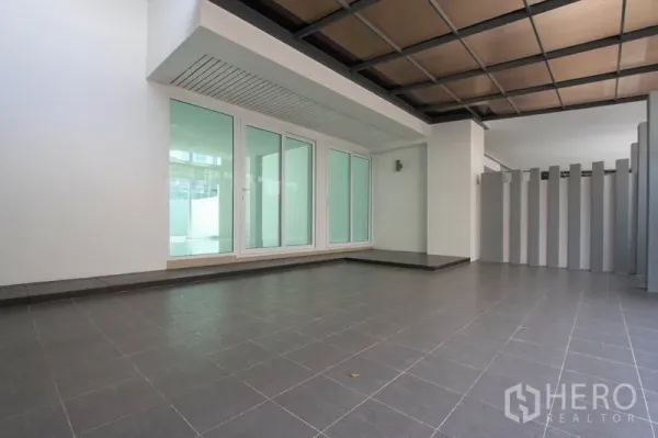 联排别墅 出售在Wang Thonglang, Bangkok - 房前宽敞的遮蔽式停车区，磨砂窗与整洁的灰色地砖。