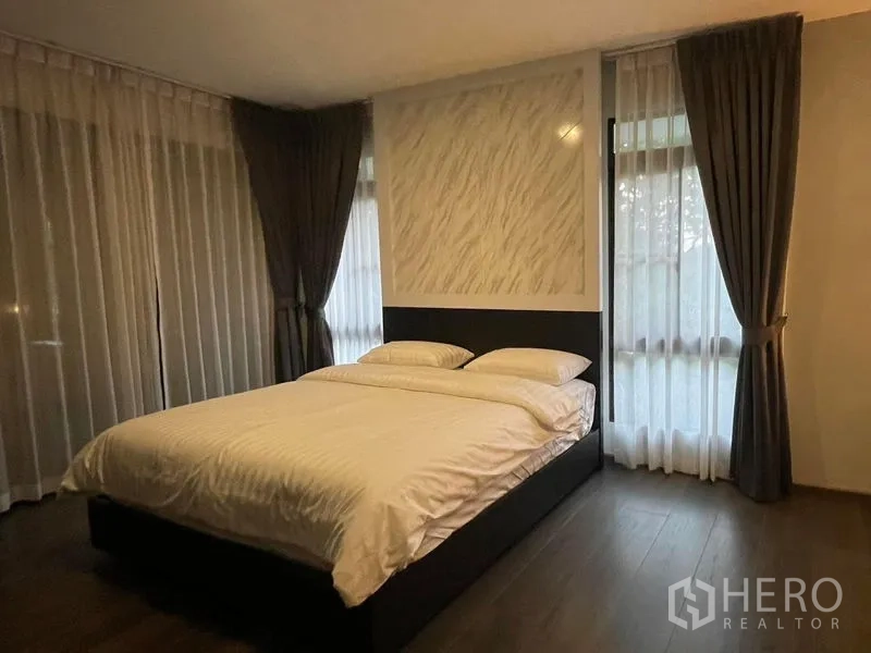 独立式住宅 出租在Bang Phli, Samut Prakan - 主卧，特大床与转角落地窗纱帘