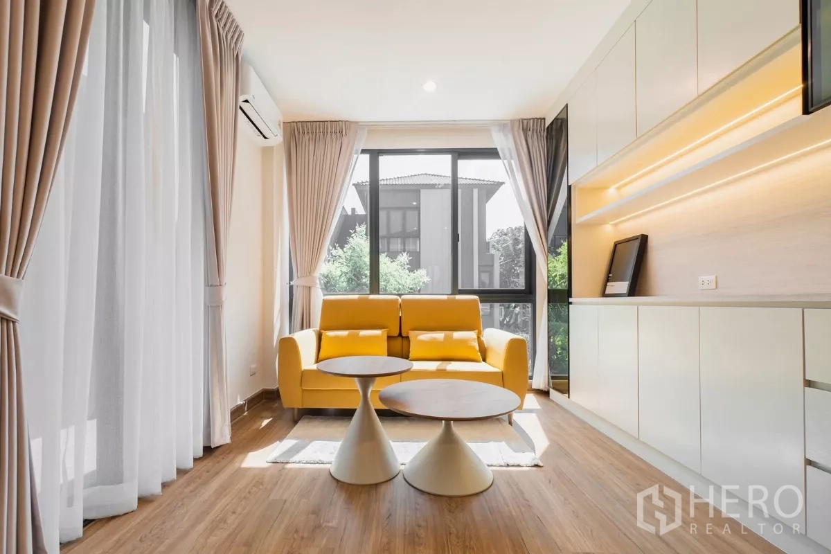 Detached House for rent or sale in Prawet, Bangkok - Cozy sitting area with yellow sofa by large window and built-in storage