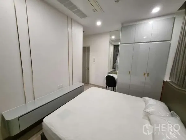 Condominium for rent - Bright bedroom with built-in wardrobe, vanity desk and a queen-size bed.