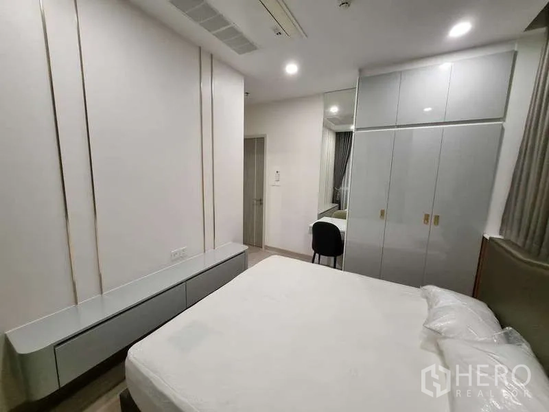 Condominium for rent - Bright bedroom with built-in wardrobe, vanity desk and a queen-size bed.