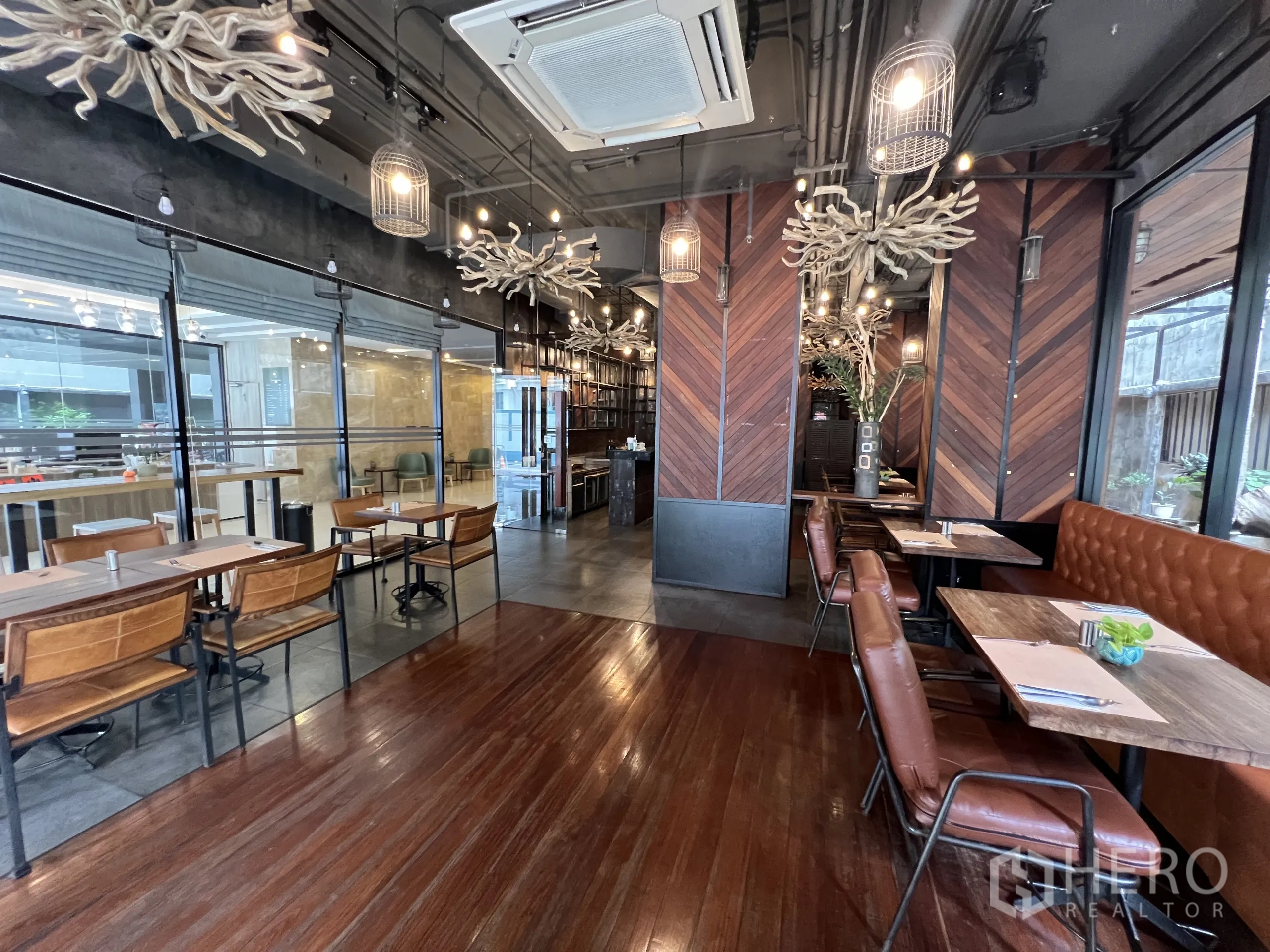 Retail Space for rent in Watthana, Bangkok - Dining area with leather banquette, small tables, glass partitions, and decorative lighting.