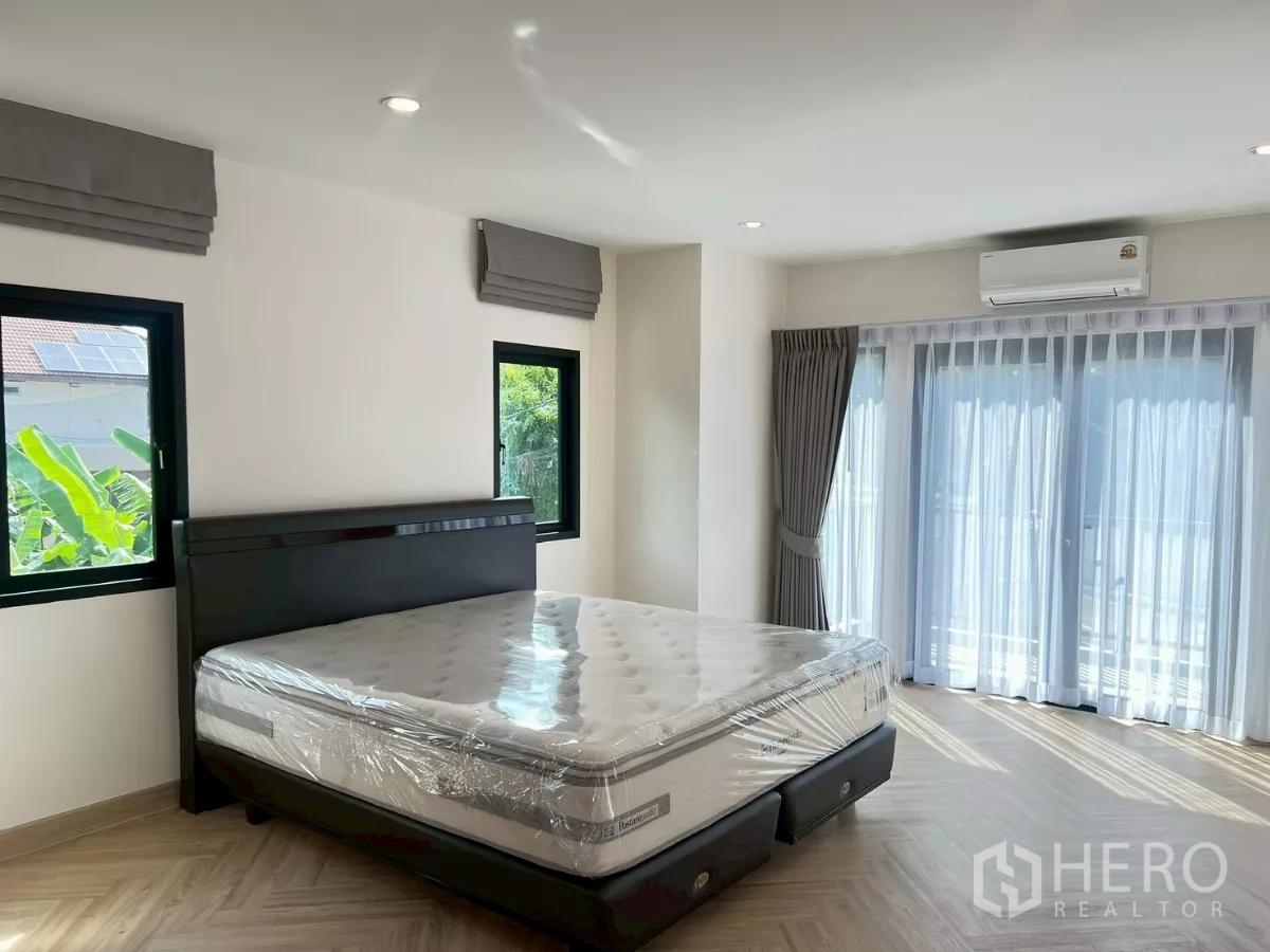 独立式住宅 出租在Suan Luang, Bangkok - 主卧细节：大窗、窗帘与空调一应俱全。