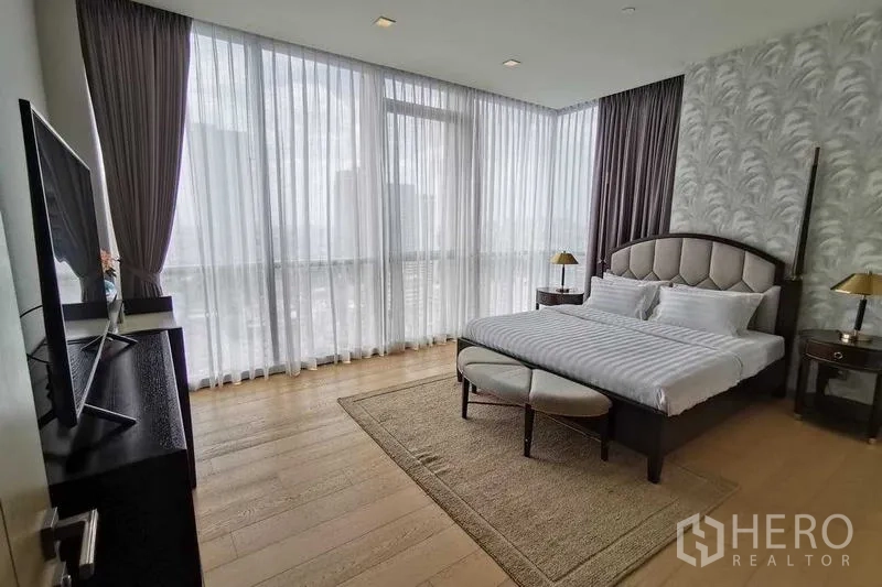 Condominium for rent or sale in Watthana, Bangkok - Spacious bedroom with TV unit and wraparound windows offering skyline views.