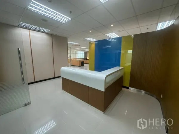 Office Space for rent in Suan Luang, Bangkok - Reception area with curved front desk, glossy tiled floor, and colorful accent wall.