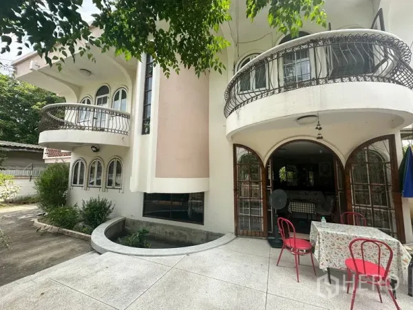 Detached House for sale in Phra Khanong, Bangkok - Close-up of the front patio with round balconies and an outdoor dining set.