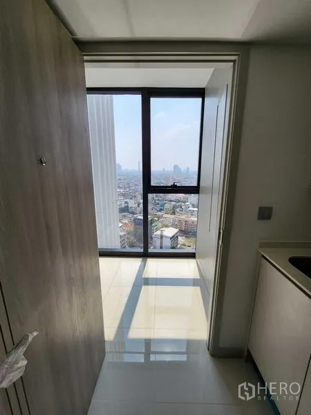 公寓 出售在Sathon, Bangkok - 入口走廊通向整高窗，可见城市天际线景观。