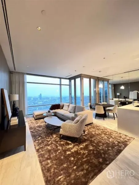 公寓 出租在Sathon, Bangkok - 开放式客餐厅，落地窗俯瞰曼谷天际线与黄昏景色。