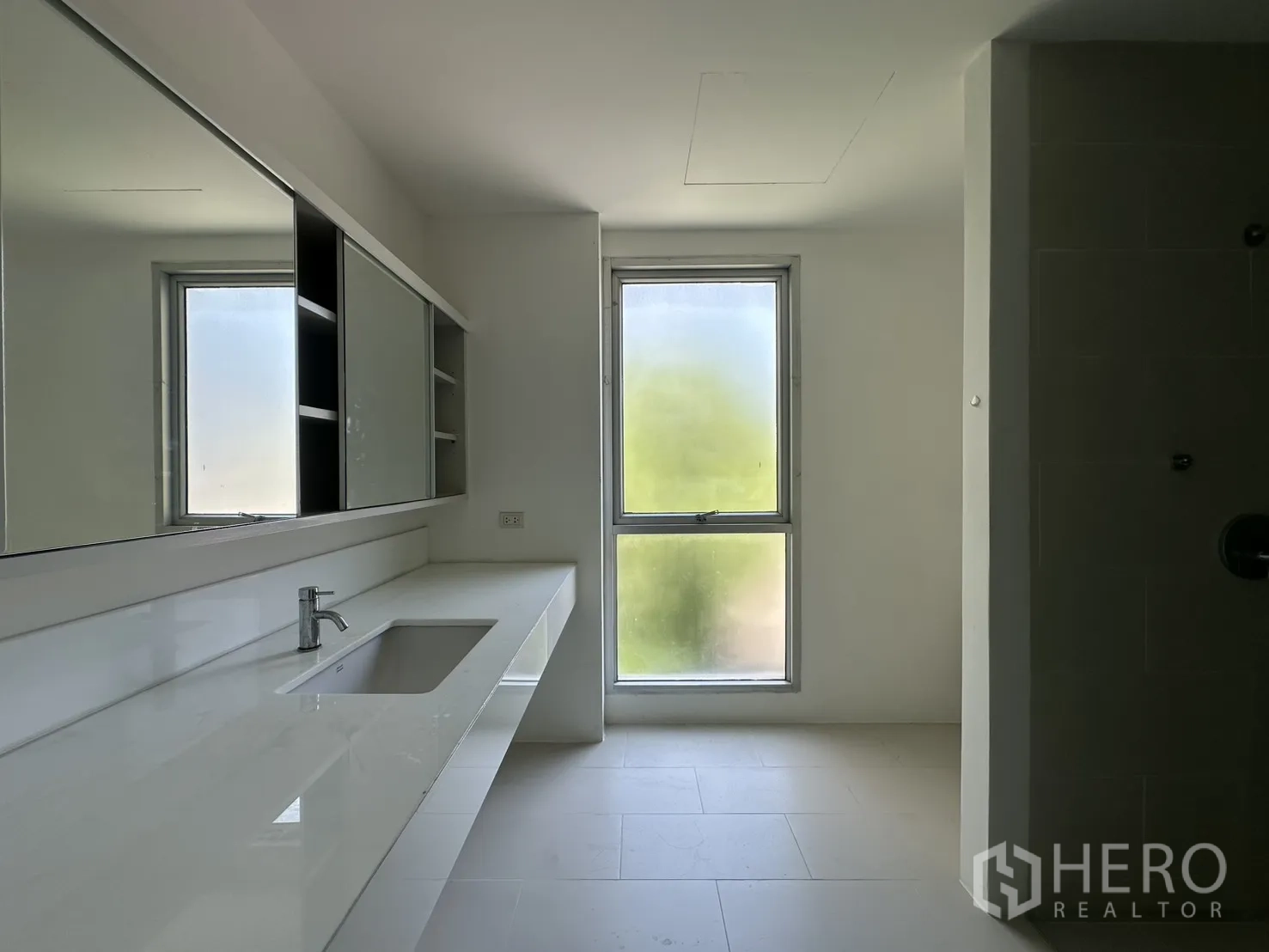 โฮมออฟฟิศ for rent in Phra Khanong, Bangkok - ห้องน้ำสว่างมีเคาน์เตอร์ยาว ตู้กระจกบานเลื่อน และหน้าต่างฝ้า.