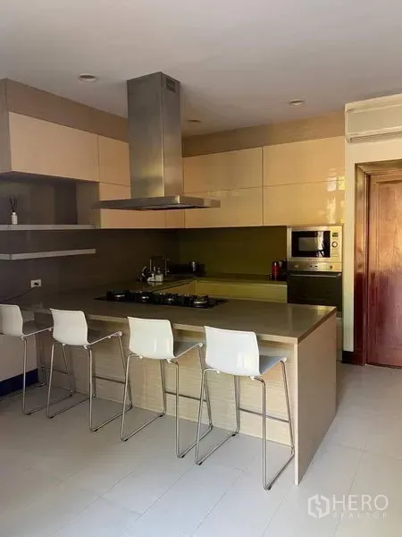 Detached House for rent in Suan Luang, Bangkok - Modern kitchen with island breakfast bar, gas cooktop, range hood and bar stools.