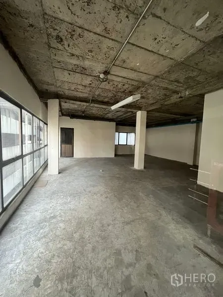 Retail Space for rent in Watthana, Bangkok - Unfurnished open-plan retail floor with large windows and exposed concrete ceiling in Asok, Bangkok.