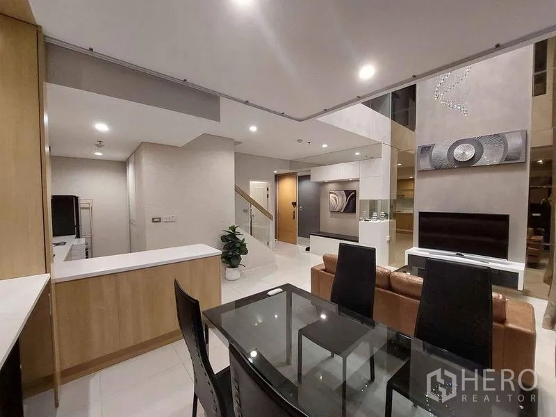 公寓 出租或出售在Ratchathewi, Bangkok - 餐区与开放式厨房相连的现代复式公寓内景。