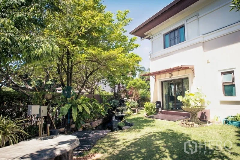 Detached House for sale in Lat Krabang, Bangkok - Lush private garden with lawn, trees, fish pond and sliding doors to the house.