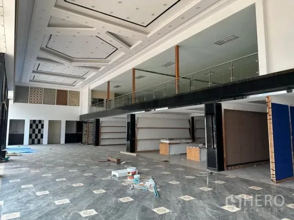 Warehouse for rent in Lam Luk Ka, Pathum Thani - Spacious showroom with mezzanine level, display walls, and wide open floor area.