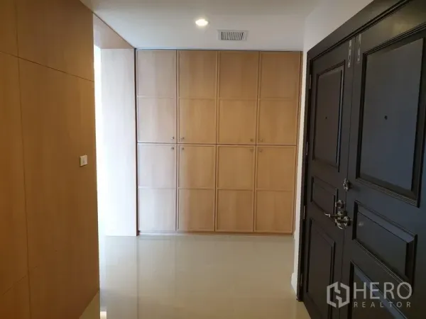 Condominium for rent in Watthana, Bangkok - Entry foyer with black double door, full-height light wood cabinets and glossy tiled floor.