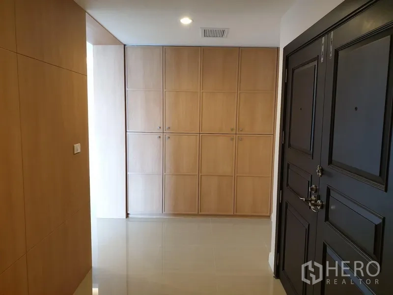 Condominium for rent in Watthana, Bangkok - Entry foyer with black double door, full-height light wood cabinets and glossy tiled floor.