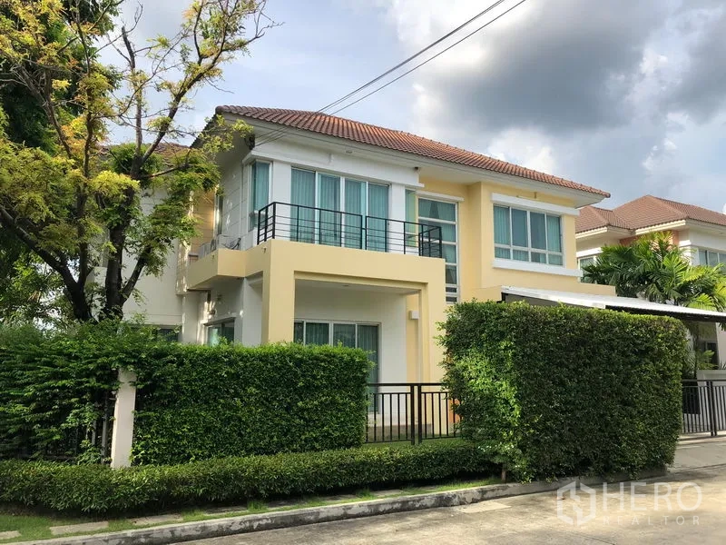 Detached House for rent in Saphan Sung, Bangkok - Two-storey detached house with balcony, hedge fence and tiled roof in a quiet residential street.