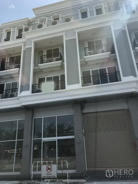 อาคารพาณิชย์ ให้เช่าในBang Na, Bangkok - ด้านหน้าอาคารพาณิชย์สมัยใหม่หลายชั้น กระจกหน้าร้าน ระเบียง และประตูม้วน ในย่านบางนา