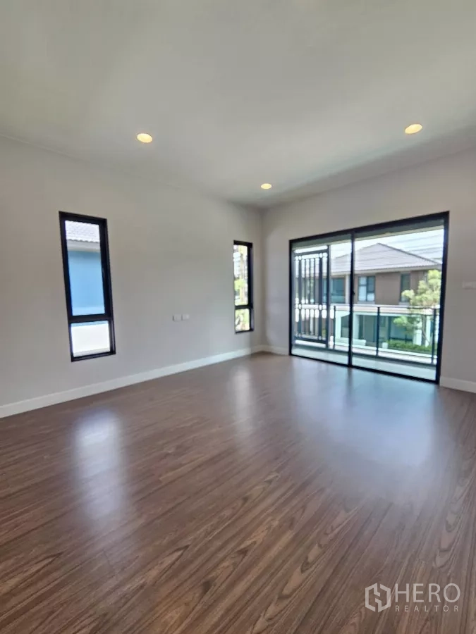 Detached House for sale in Lam Luk Ka, Pathum Thani - Master bedroom with balcony access and floor-to-ceiling windows.