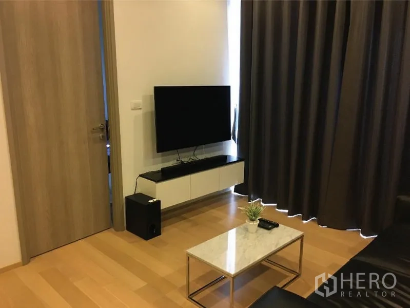 公寓 出租或出售在Watthana, Bangkok - 客厅配壁挂电视柜、大理石茶几与落地遮光窗帘。