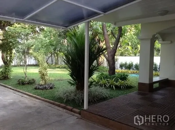 独立式住宅 出租在Ratchathewi, Bangkok - 带顶露台与车道，眺望修剪整齐的草坪和热带植物。
