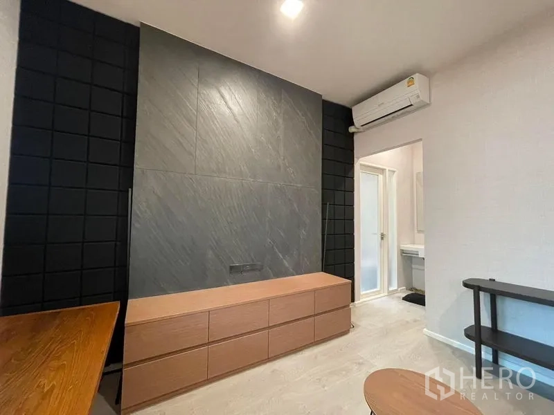 Detached House for rent in Prawet, Bangkok - Multipurpose media room with dark feature wall, low cabinet and air conditioning.