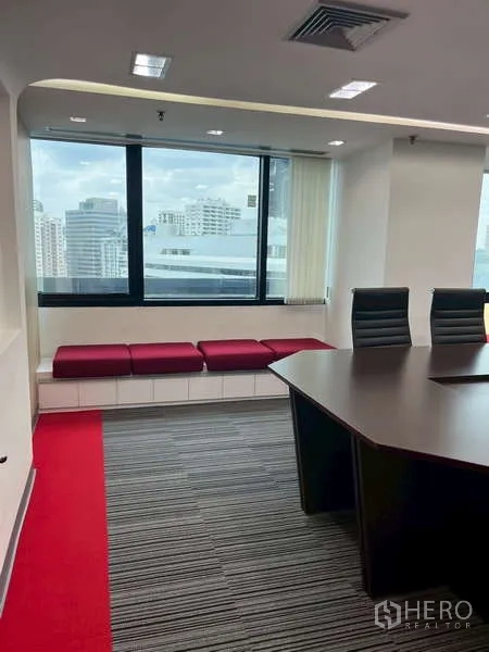 Office Space for rent - Meeting room corner with window bench seating and skyline view.