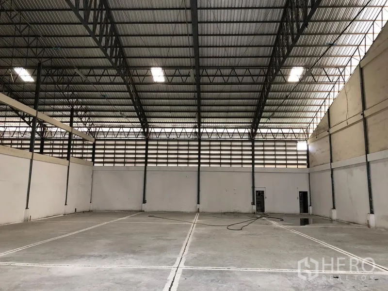 Warehouse for rent in Bang Phli, Samut Prakan - Clear‑span warehouse floor with marked bays, ventilated upper walls and a tall metal roof structure.