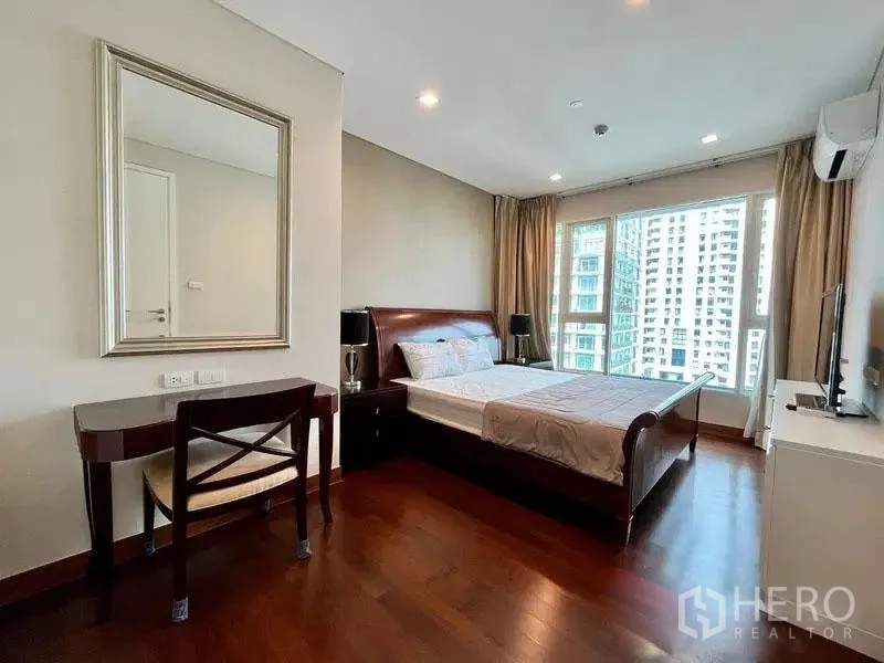 Condominium for rent in Watthana, Bangkok - Master bedroom with king bed, desk and wide windows offering city views.