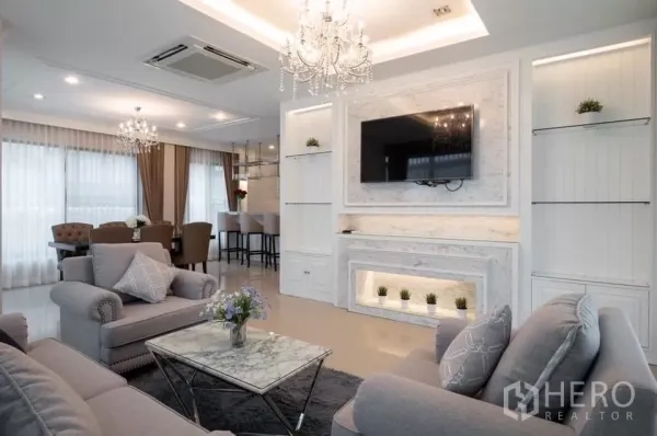 Detached House for rent in Prawet, Bangkok - Elegant living room featuring a marble TV wall, built-in shelves and plush seating.