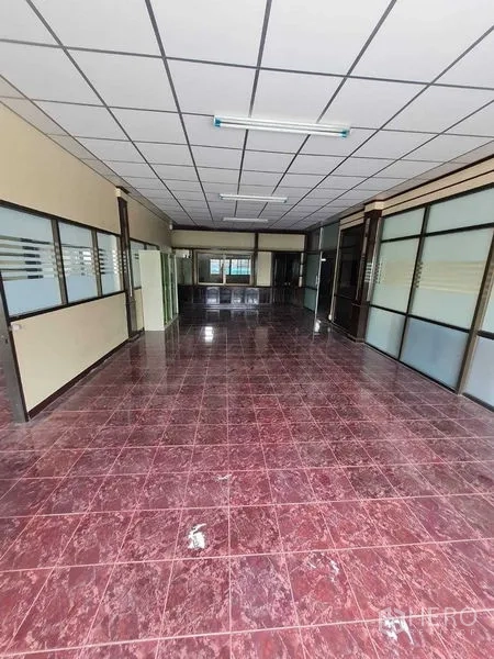 Warehouse for rent in Bang Yai, Nonthaburi - Long office zone with glass partitions, suspended ceiling and tiled floor.