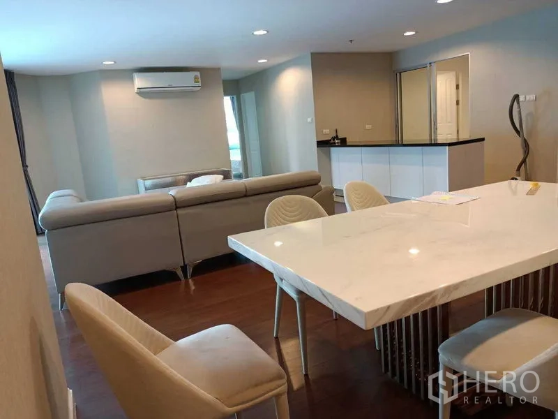 คอนโด ให้เช่าหรือขายในHuai Khwang, Bangkok - พื้นที่นั่งเล่นและทานอาหารแบบเปิดโล่ง โต๊ะหินอ่อน โซฟารูปตัวแอล และพื้นไม้.