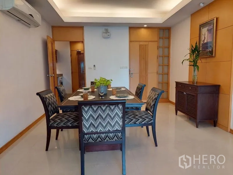 Apartment for rent - Dining room with a six-seat table and patterned chairs under recessed lighting.
