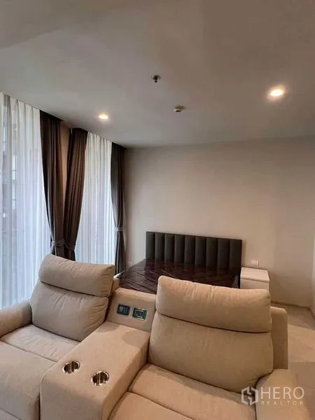 公寓 出租在Pathum Wan, Bangkok - 客厅设双人躺椅与卧室区域，临近大落地窗