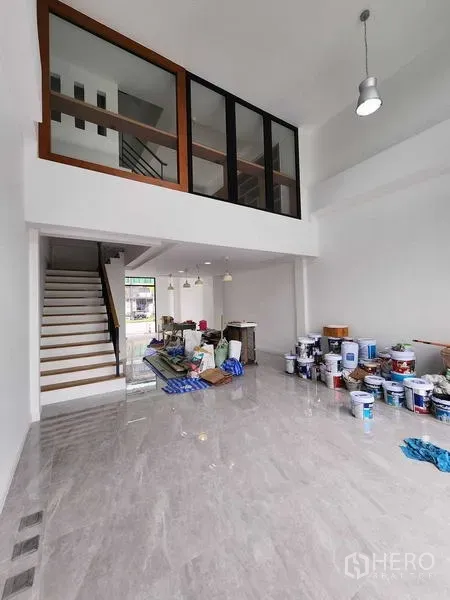 带办公室的家 出租在Prawet, Bangkok - 现代商住两用办公楼的挑高大堂与夹层，楼梯与亮面瓷砖地面，正在轻度整修。