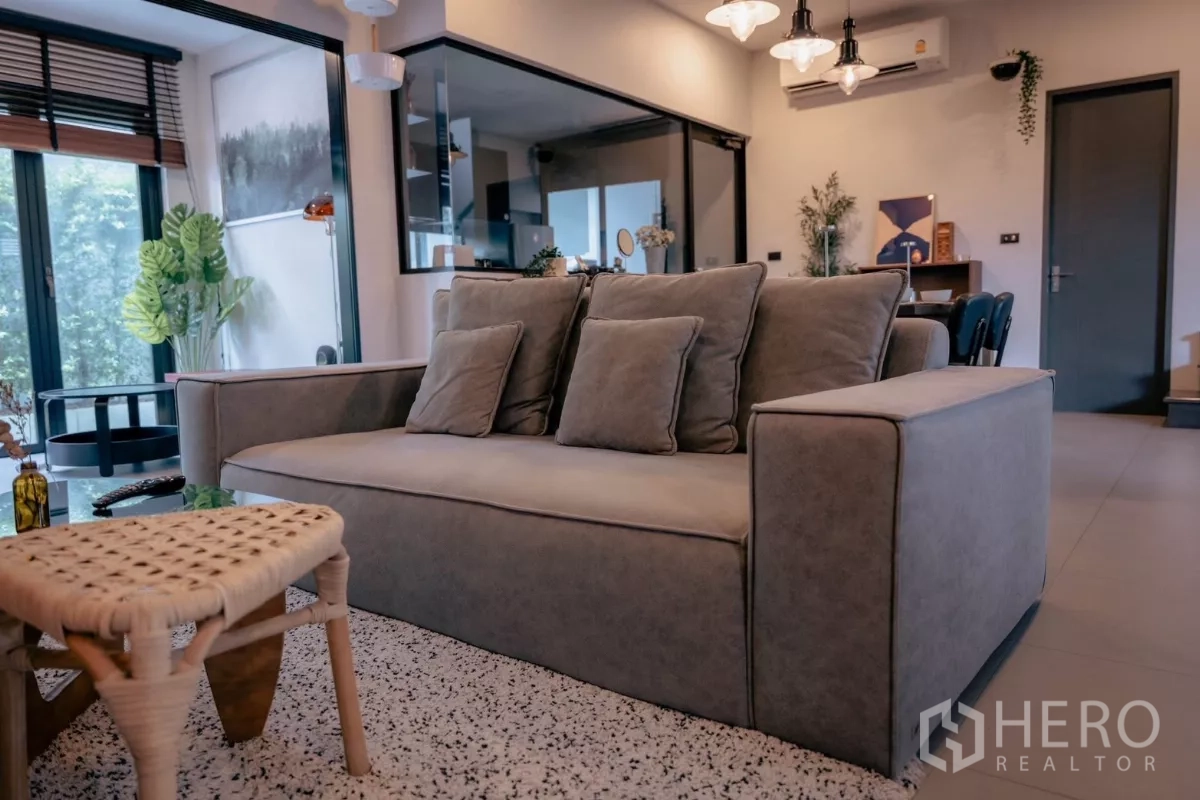 Detached House for rent or sale in Bang Phli, Samut Prakan - Cozy gray sofa in a bright open‑plan living space.