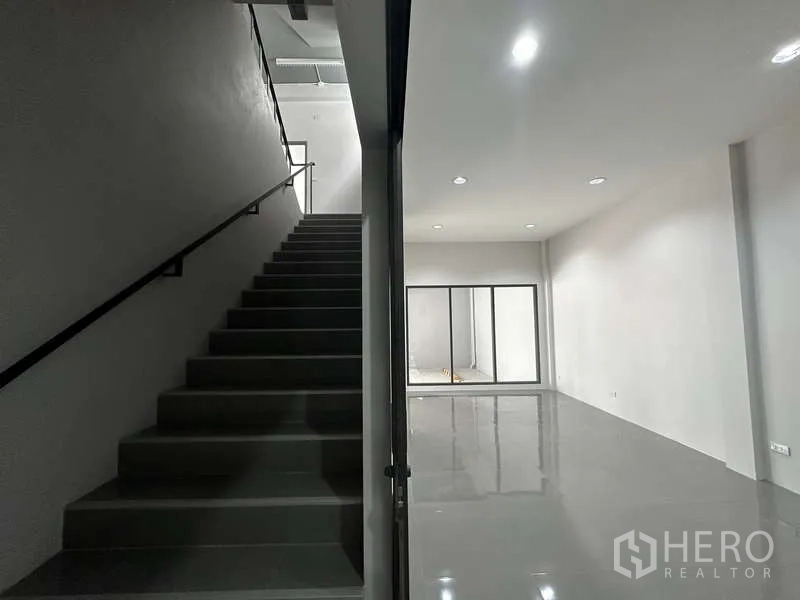 Factory for rent or sale in Bang Bua Thong, Nonthaburi - Ground-floor lobby with staircase and glass partition to office area.