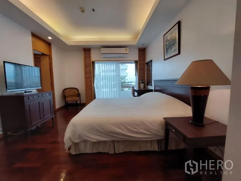 Apartment for rent - Master bedroom with tray ceiling, TV cabinet and balcony access in a Sathon apartment.