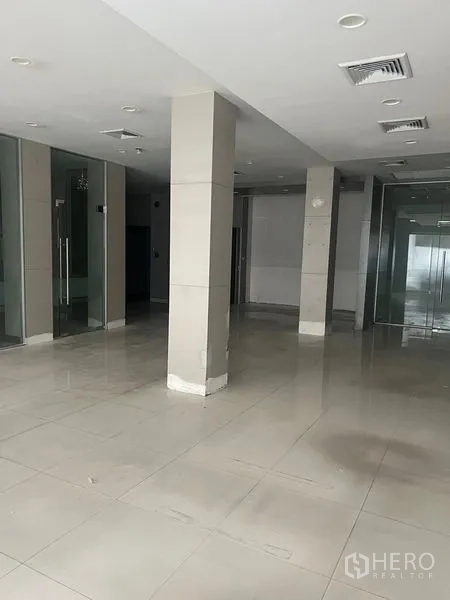 店屋 出租在Samphanthawong, Bangkok - 宽敞大厅区域，瓷砖地、立柱与玻璃入口。