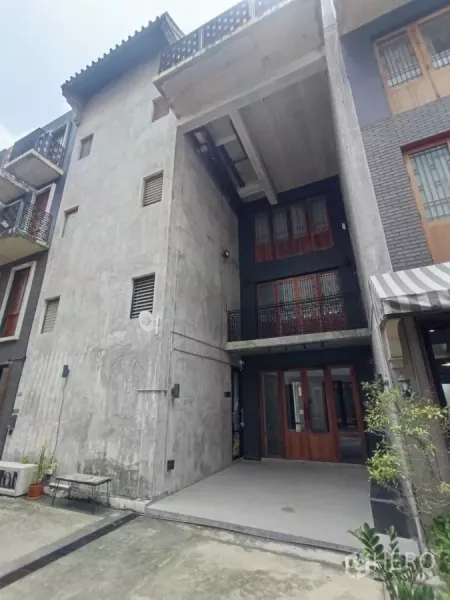 带办公室的家 出租在Pathum Wan, Bangkok - 曼谷巴吞旺区出租的现代Loft风家庭办公楼，混凝土外立面与门前停车区。