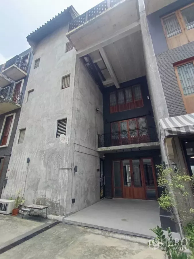 带办公室的家 出租在Pathum Wan, Bangkok - 曼谷巴吞旺区出租的现代Loft风家庭办公楼，混凝土外立面与门前停车区。