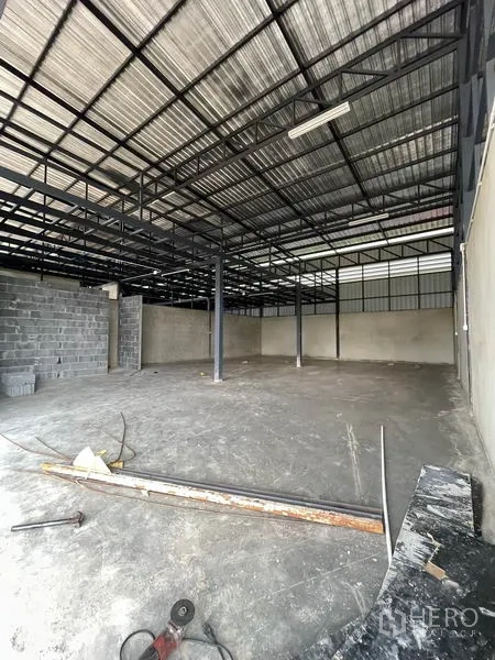 货栈 出租在Pathum Thani - 仓库内部，高钢结构屋架、混凝土地面与立柱。